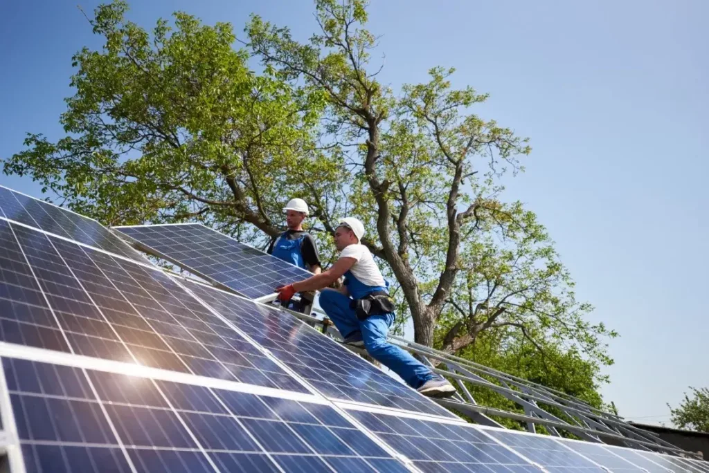 Two installers fitting solar panels on a roof