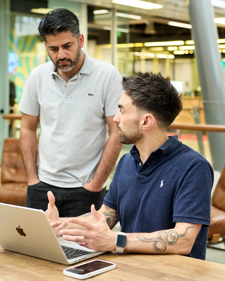 Two of the DUNK team going through an account at the studio bench